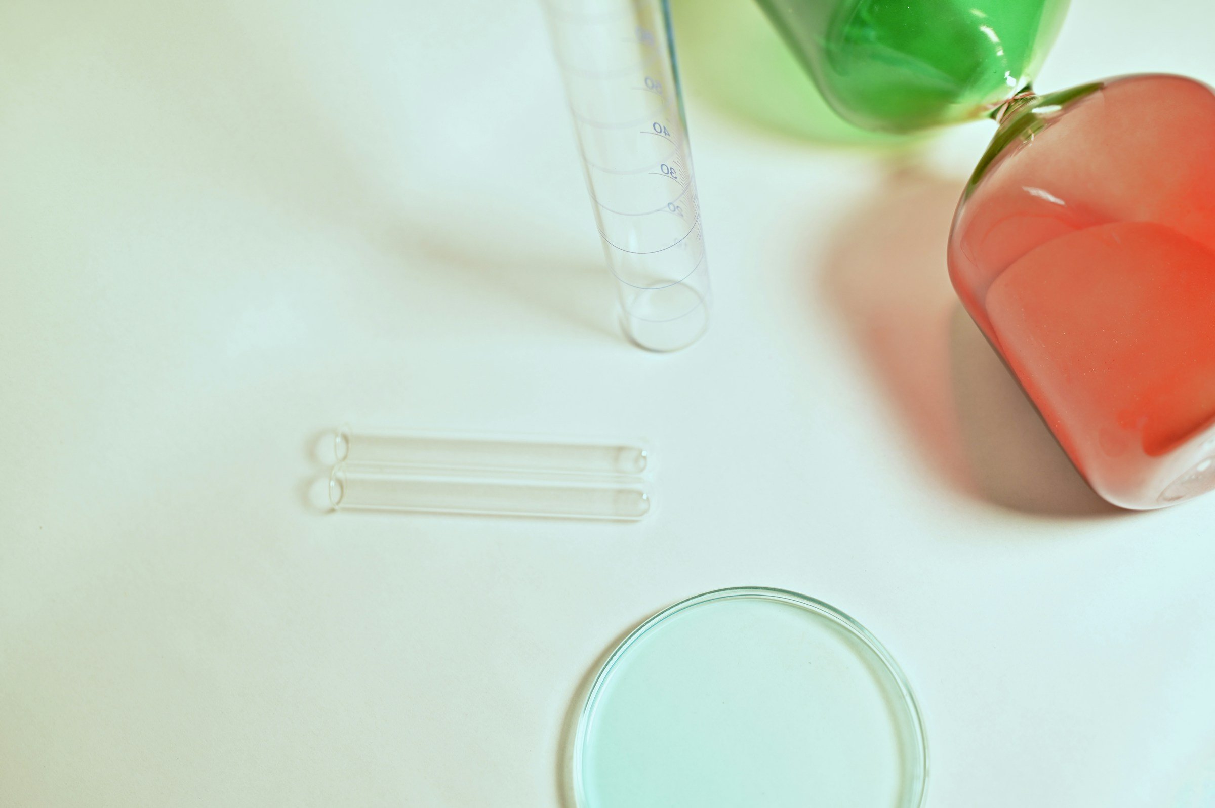 Laboratory glassware in pastel hues on a light background