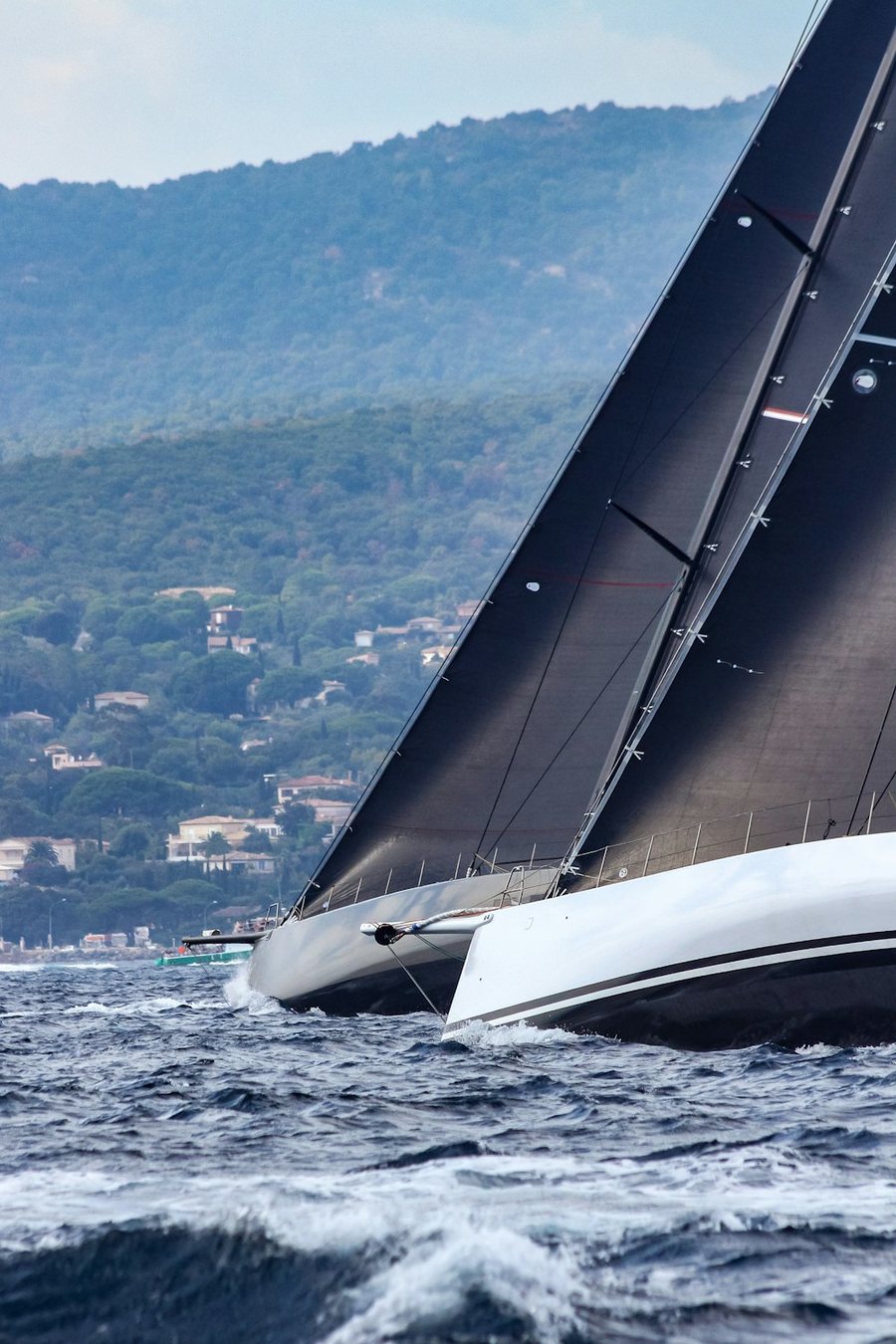 Racing yacht with black mainsail heeling close-hauled