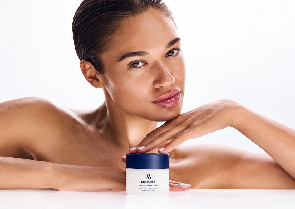 Woman leaning behind an Ariel Ascot LunaCell8 cream jar, on a white background
