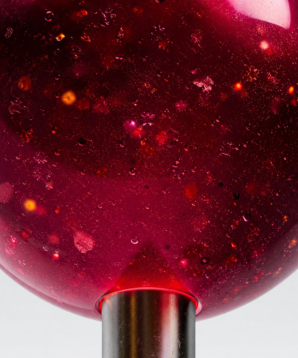 Gouttes et paillettes rouges sur le verre d'un flacon cosmétique, visuel de survol du projet Biostem